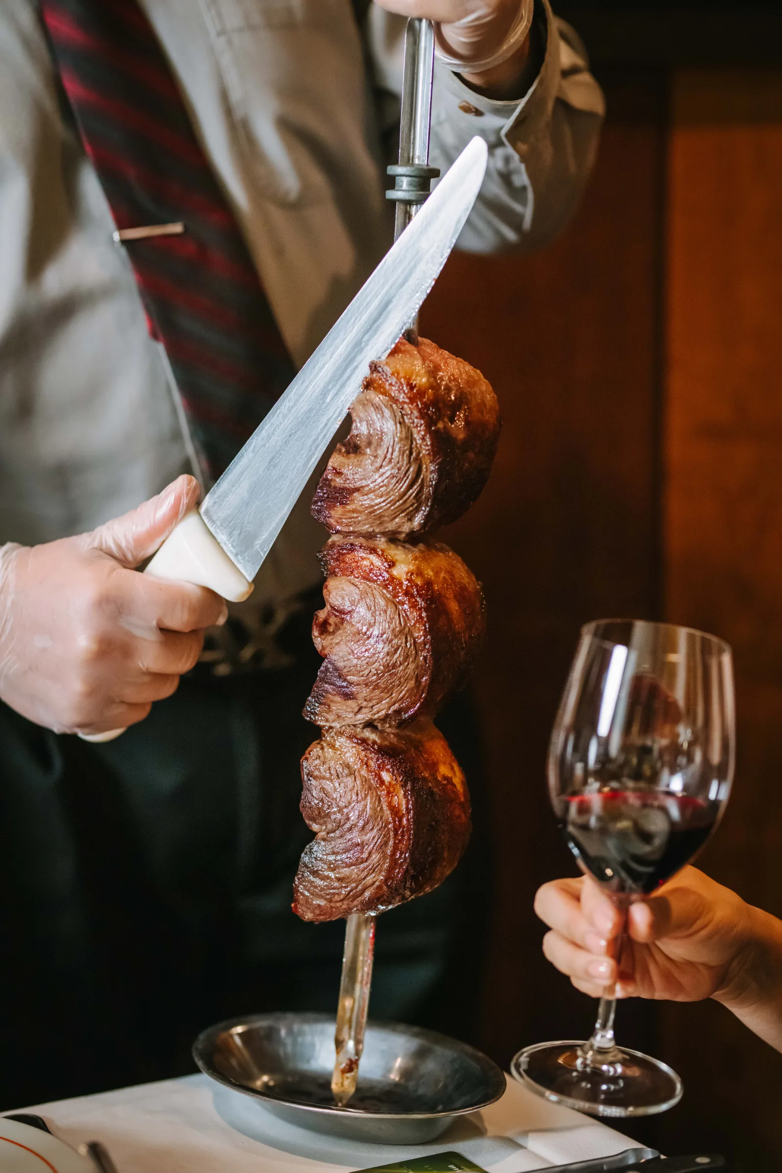 Gaucho carving fire-roasted meat tableside at VB Steakhouse